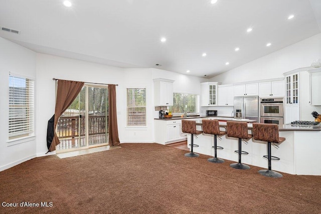 32722 N 10th Ave, Spirit Lake, ID 83869 - kitchen featuring stainless steel appliances, dark carpet, dark countertops, a breakfast bar, and glass insert cabinets
