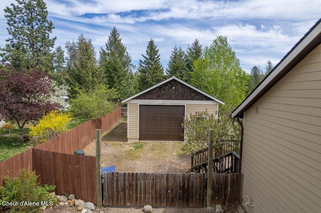 32722 N 10th Ave, Spirit Lake, ID 83869 - view of side of home with a detached garage, an outbuilding, fence, and dirt driveway