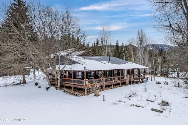 snow covered house with a deck