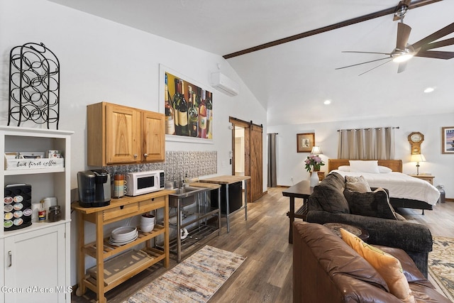 bedroom with ceiling fan, a barn door, a wall unit AC, dark wood-style floors, and high vaulted ceiling