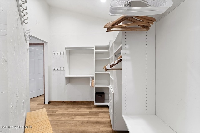 walk in closet with wood finished floors