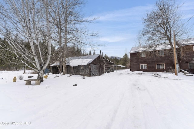 yard layered in snow featuring an outbuilding