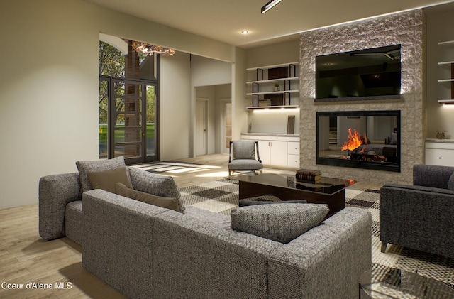 living room with a tiled fireplace, a notable chandelier, and wood finished floors