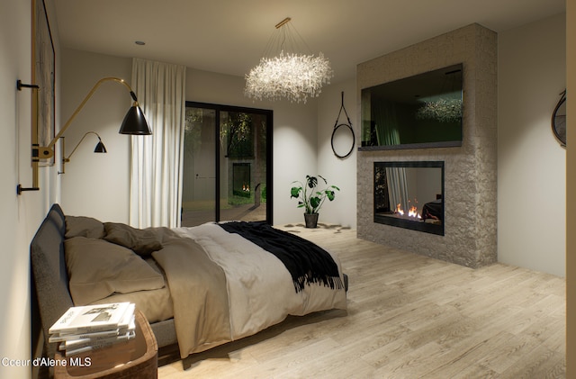 bedroom with access to exterior, a chandelier, a lit fireplace, and wood finished floors