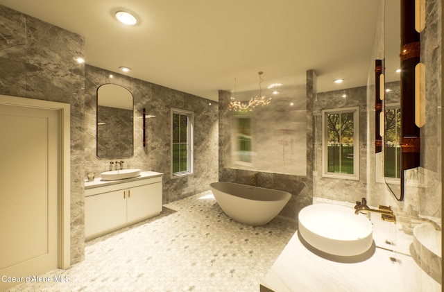 bathroom featuring tile walls, a freestanding tub, two vanities, and a sink