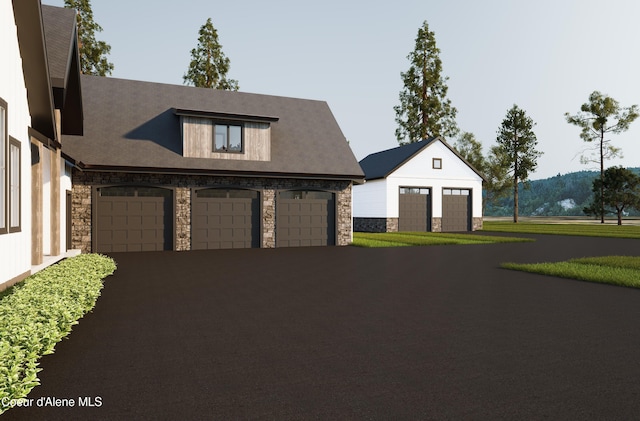 view of front of house featuring aphalt driveway, a garage, and stone siding