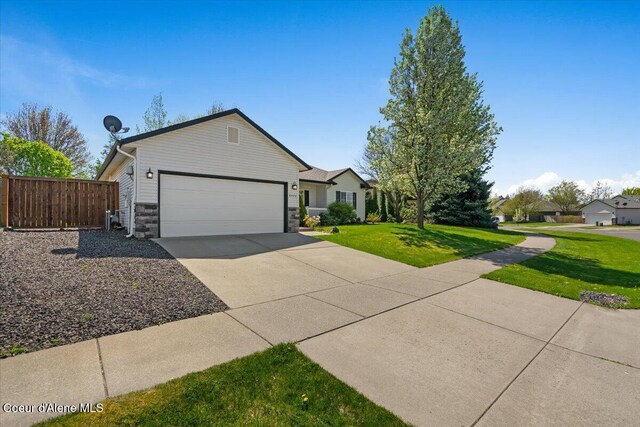 8920 N Torrey Ln, Hayden, ID 83835 - ranch-style house featuring driveway, a garage, fence, a front lawn, and stone siding