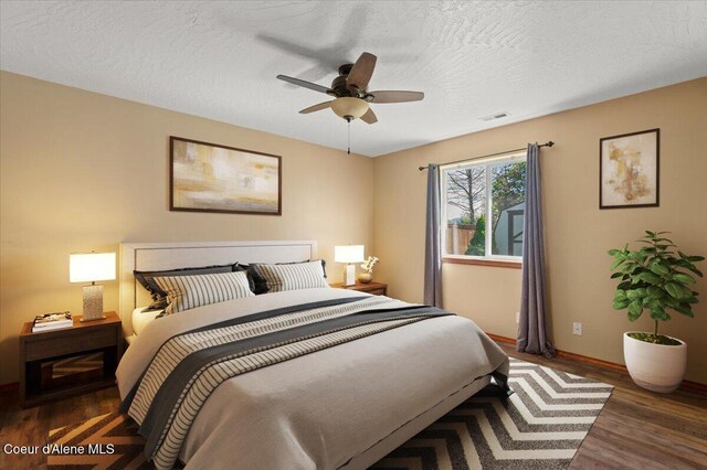 8920 N Torrey Ln, Hayden, ID 83835 - bedroom with a textured ceiling, a ceiling fan, baseboards, wood finished floors, and visible vents