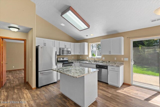 8920 N Torrey Ln, Hayden, ID 83835 - kitchen with white cabinets, stainless steel appliances, light stone countertops, and dark wood finished floors