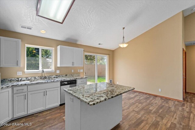 8920 N Torrey Ln, Hayden, ID 83835 - kitchen with dark wood-style flooring, light stone countertops, a sink, dishwasher, and a center island