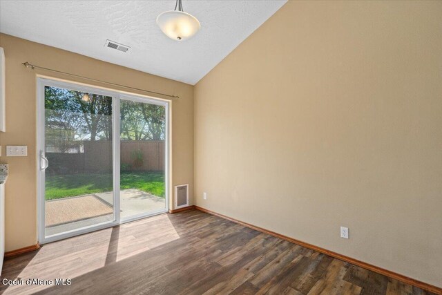 8920 N Torrey Ln, Hayden, ID 83835 - empty room featuring dark wood-style flooring, baseboards, visible vents, and lofted ceiling