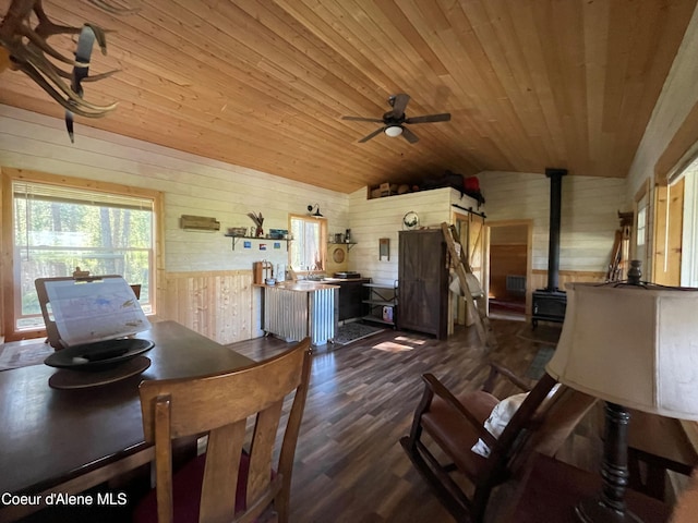 1942 Two Tail Rd, Bonners Ferry, ID 83805 - dining space with wood walls, lofted ceiling, a wood stove, wooden ceiling, and a ceiling fan