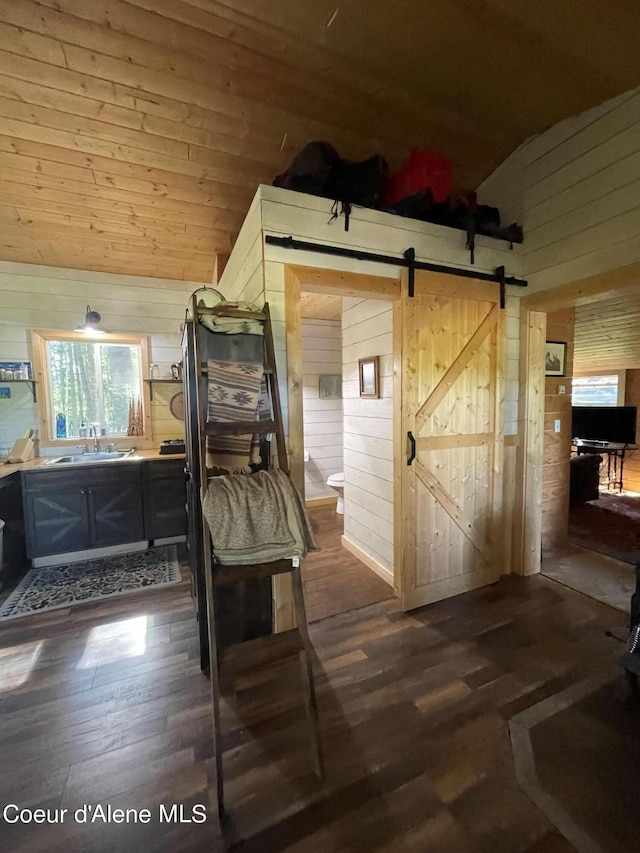 1942 Two Tail Rd, Bonners Ferry, ID 83805 - kitchen featuring wood walls, a barn door, dark wood finished floors, and high vaulted ceiling
