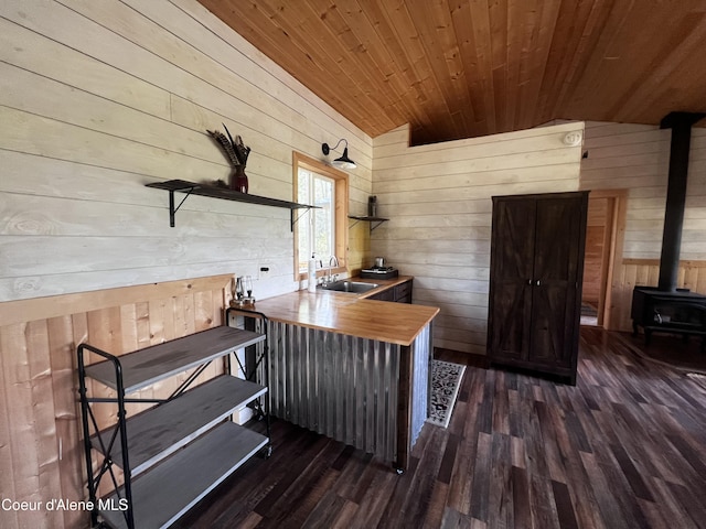1942 Two Tail Rd, Bonners Ferry, ID 83805 - office area with wood walls, a wood stove, lofted ceiling, wood ceiling, and dark wood-style floors