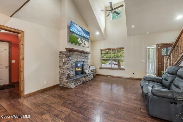 living area with wood-type flooring, high vaulted ceiling, a fireplace, and ceiling fan