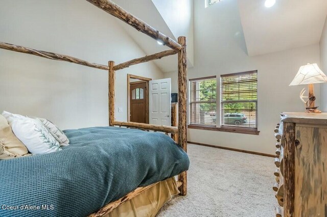 carpeted bedroom with baseboards and high vaulted ceiling