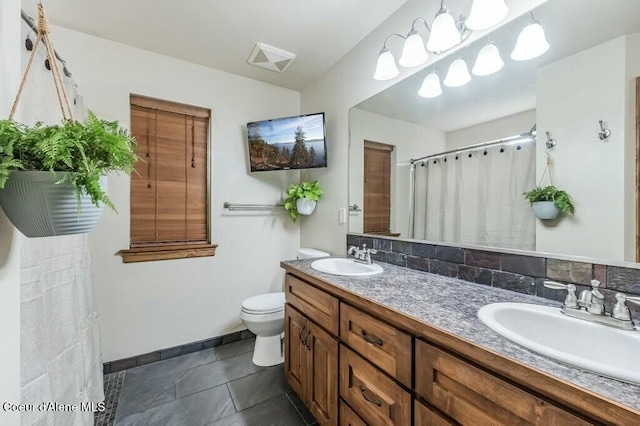 bathroom with toilet, a sink, double vanity, and tile patterned flooring