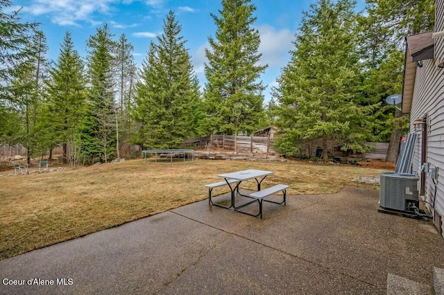 view of patio with cooling unit, fence, and a trampoline