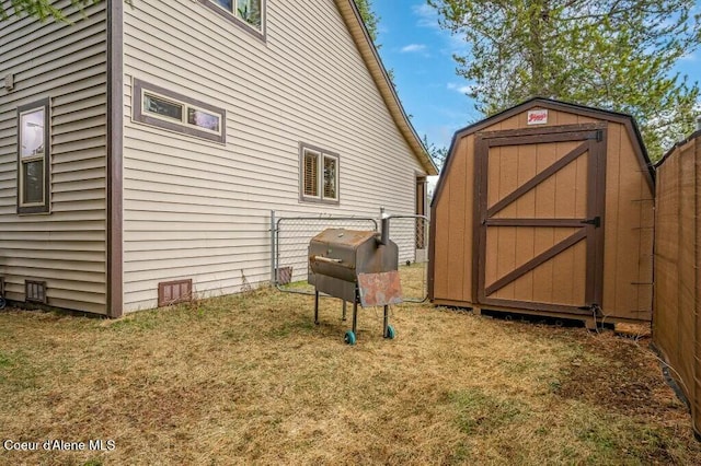 view of side of property featuring a yard, an outbuilding, a shed, and fence