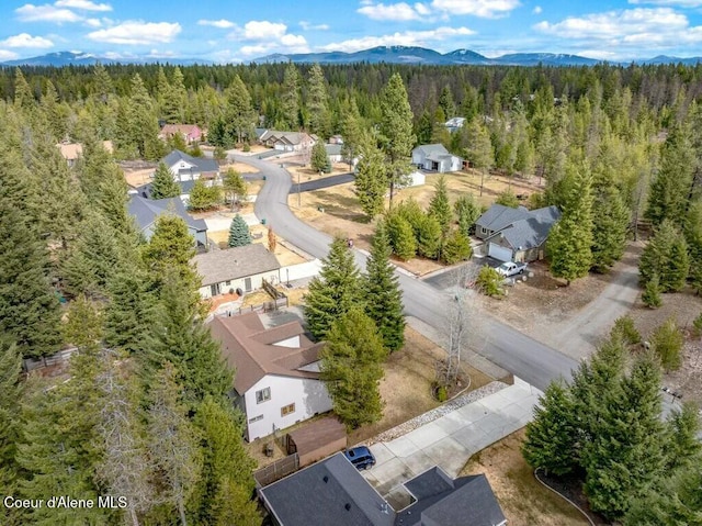 drone / aerial view featuring a mountain view, a view of trees, and a residential view