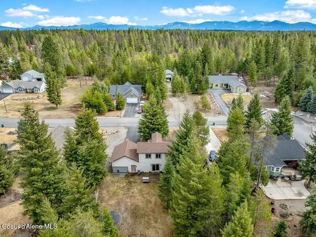 birds eye view of property featuring a mountain view and a view of trees