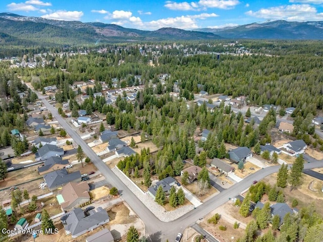 birds eye view of property with a wooded view and a mountain view