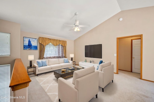 living room featuring a ceiling fan, baseboards, high vaulted ceiling, and light colored carpet