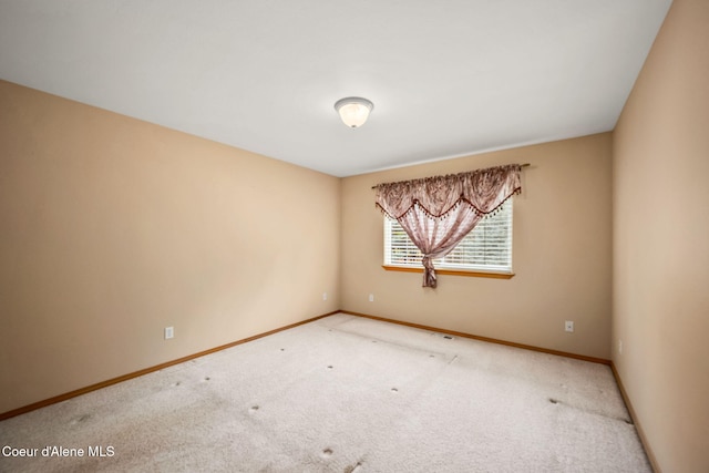 empty room featuring carpet flooring and baseboards