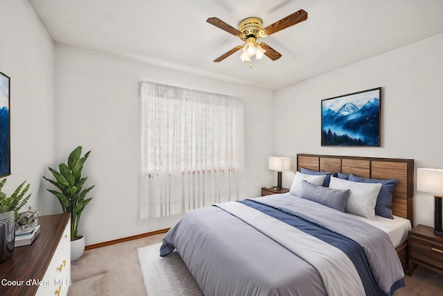carpeted bedroom with ceiling fan and baseboards