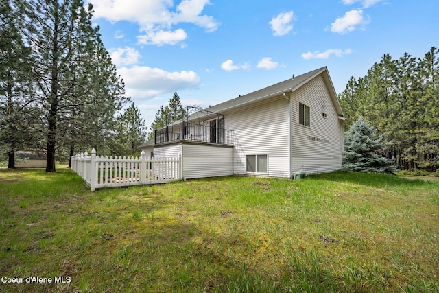 back of house featuring fence and a lawn