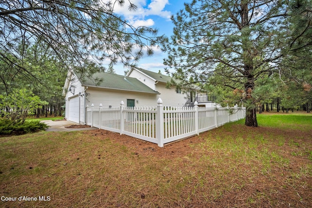 exterior space featuring driveway, fence private yard, and a garage