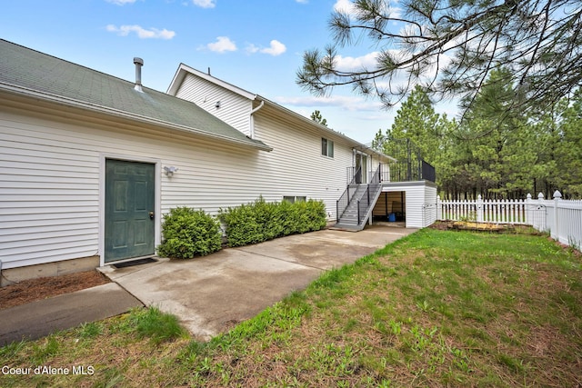 exterior space with a yard, stairs, a wooden deck, and fence