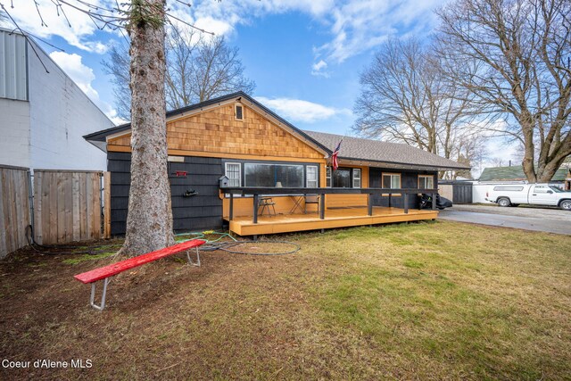 view of front of house featuring a front yard, a deck, and fence