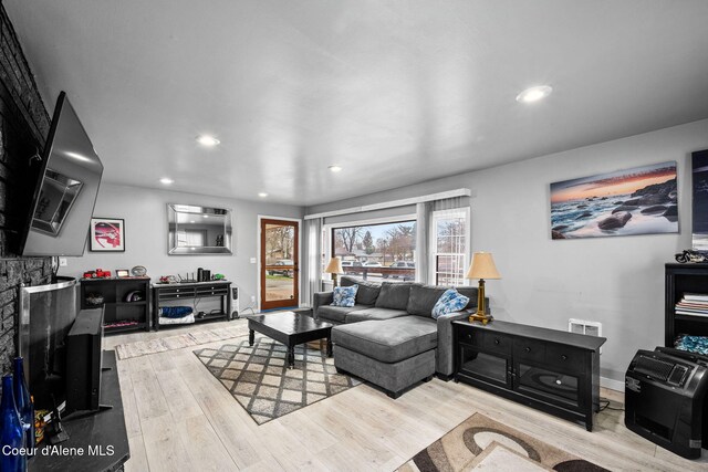 living area with recessed lighting, baseboards, and wood finished floors