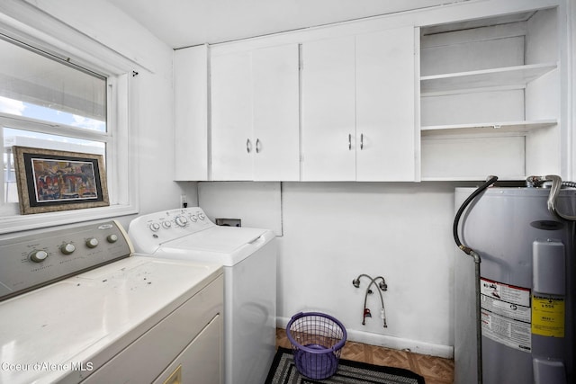 washroom with cabinet space, washing machine and dryer, and water heater