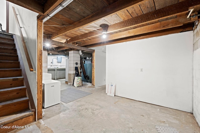 unfinished below grade area featuring stairway and separate washer and dryer