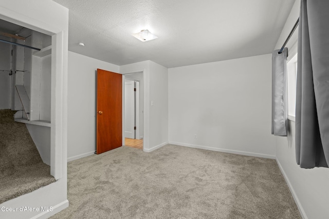 unfurnished bedroom with baseboards, carpet, and a textured ceiling