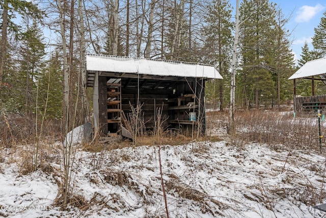 snow covered structure with an outdoor structure and an outbuilding