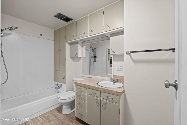 bathroom featuring vanity, wood finished floors, visible vents, tub / shower combination, and toilet