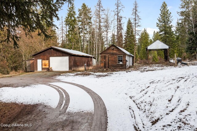 yard layered in snow with an outbuilding, a gazebo, and a detached garage