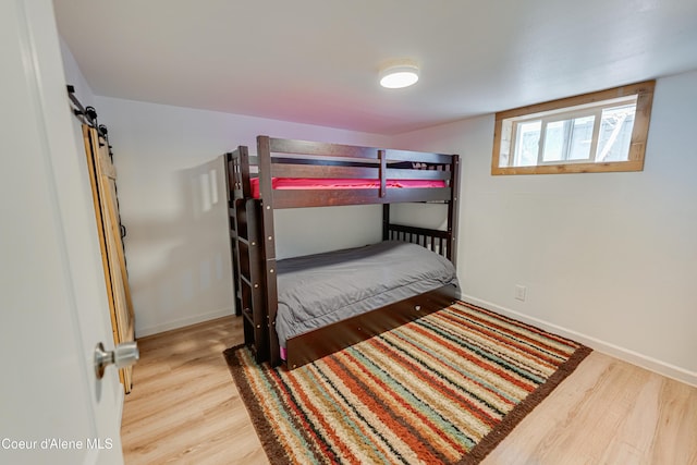 bedroom with baseboards and wood finished floors