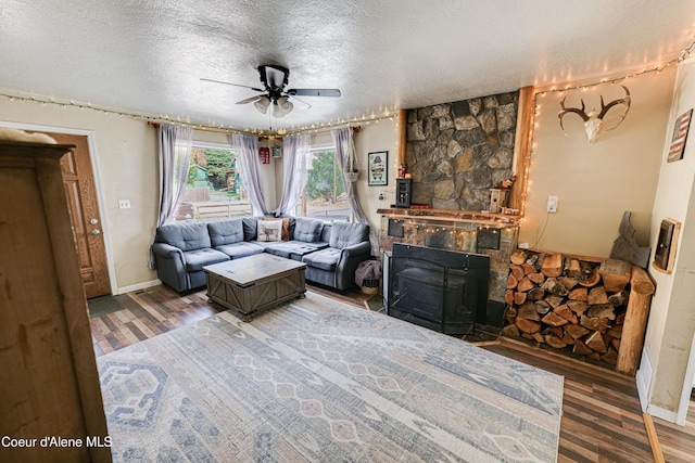 living room with a textured ceiling, wood finished floors, and a ceiling fan