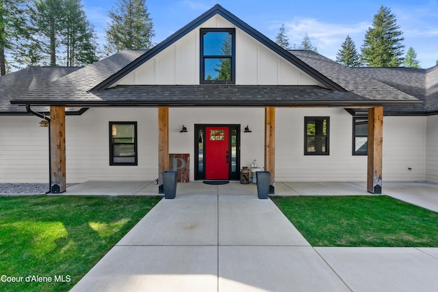 modern farmhouse style home with board and batten siding, a front lawn, and roof with shingles