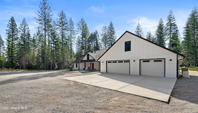 view of side of home with concrete driveway, central AC unit, and board and batten siding