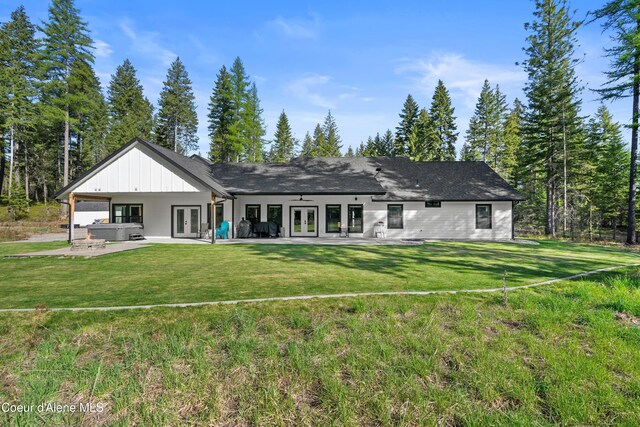 rear view of property featuring french doors, a yard, and a patio area