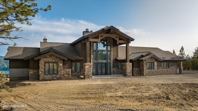 4579 E Plum Rd, Coeur Dalene, ID 83814 - view of front facade featuring stone siding, a chimney, and a shingled roof