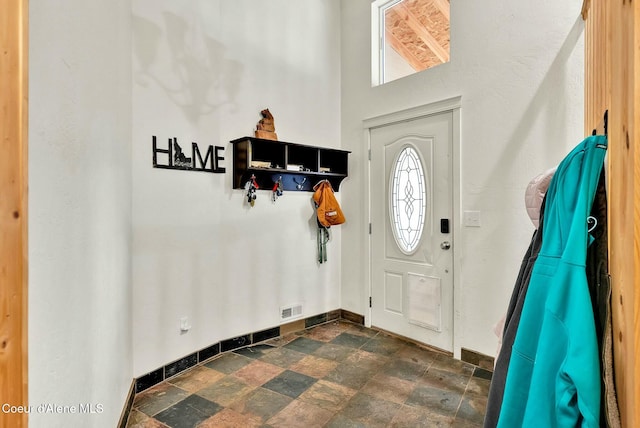 entrance foyer featuring stone finish floor, visible vents, and baseboards