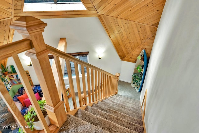 staircase with a skylight, carpet floors, and wooden ceiling
