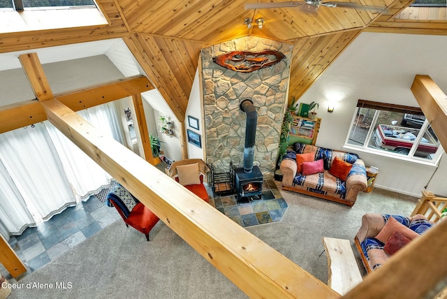 living room featuring carpet flooring, wooden ceiling, high vaulted ceiling, and a wood stove