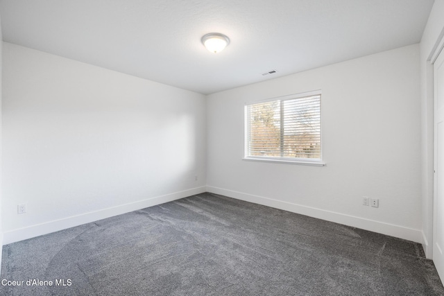 1006 E Garden Ave, Coeur Dalene, ID 83814 - unfurnished room with baseboards, dark colored carpet, and visible vents